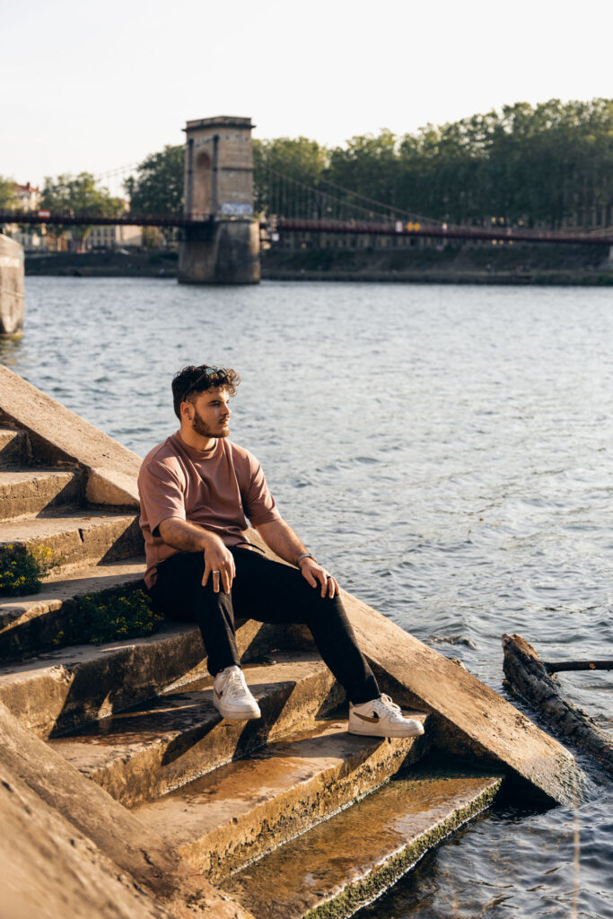 Shooting photo lifestyle d’un homme dans la vingtaine assis sur les marches d’un quai de Saône à Lyon